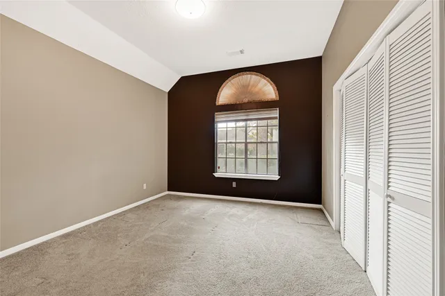 an empty room with windows and closet