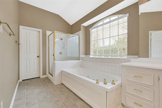 a bathroom with a tub a sink and a window