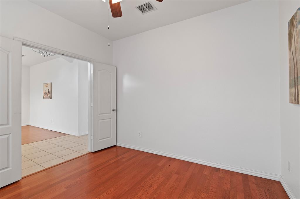 2617 Hollow Ridge Drive Denton, TX 76210 - Photo 19 of 32 an empty room with wooden floor cabinet and ceiling fan