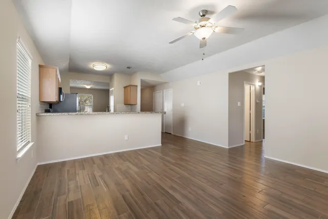 a view of a kitchen with wooden floor and a ceiling fan