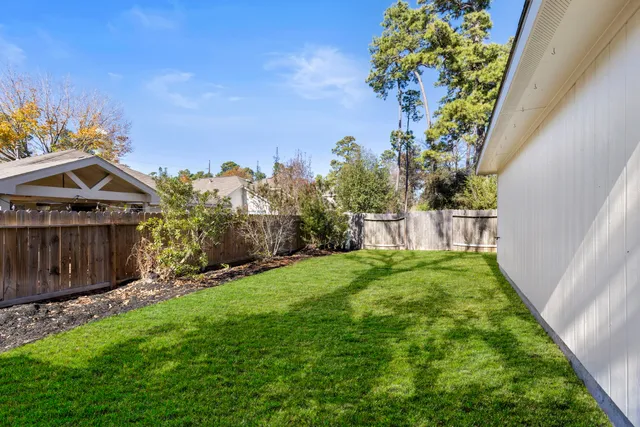 a view of a backyard with potted plants and wooden fence