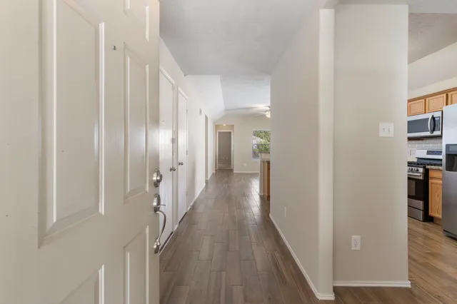 a view of a hallway with wooden floor and staircase