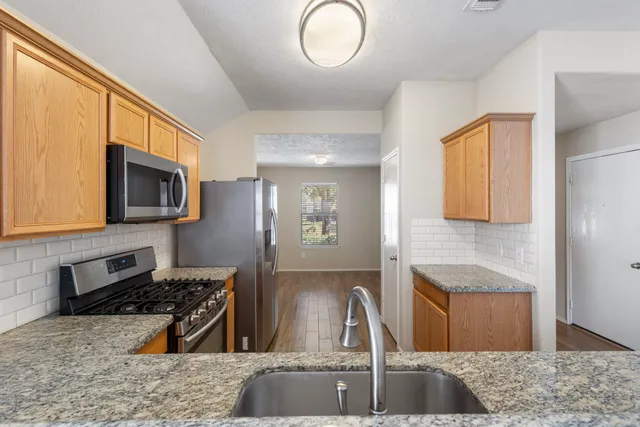 a kitchen with stainless steel appliances granite countertop a sink stove and microwave