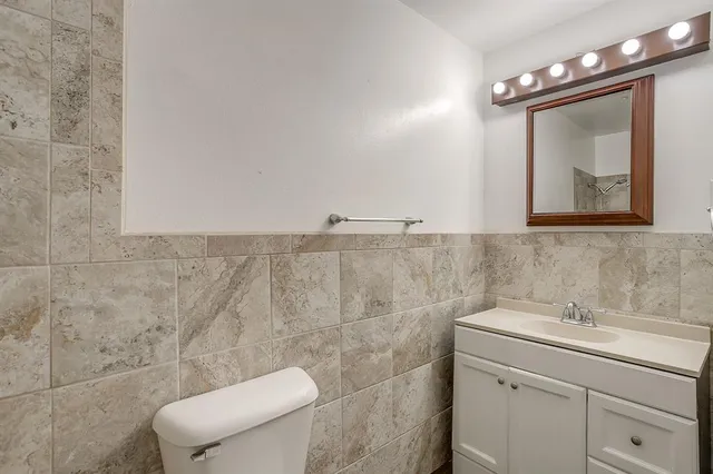 a bathroom with a sink mirror and toilet