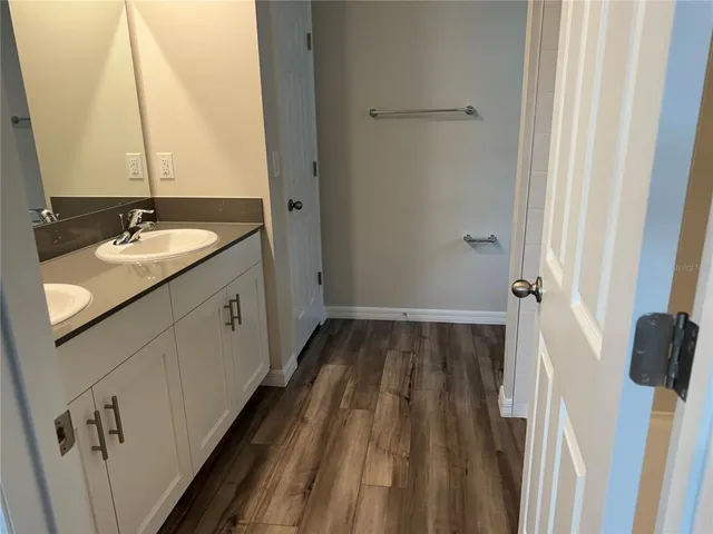 a bathroom with a sink and mirror with bathtub