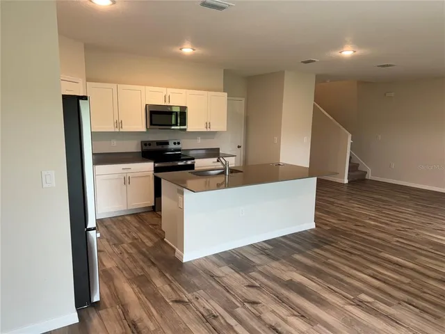 a kitchen with stainless steel appliances a refrigerator and a stove top oven
