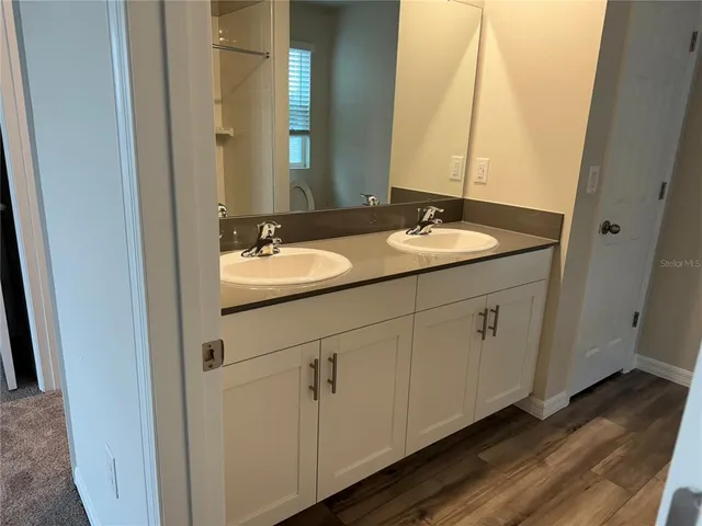 a bathroom with a double vanity sink and a mirror