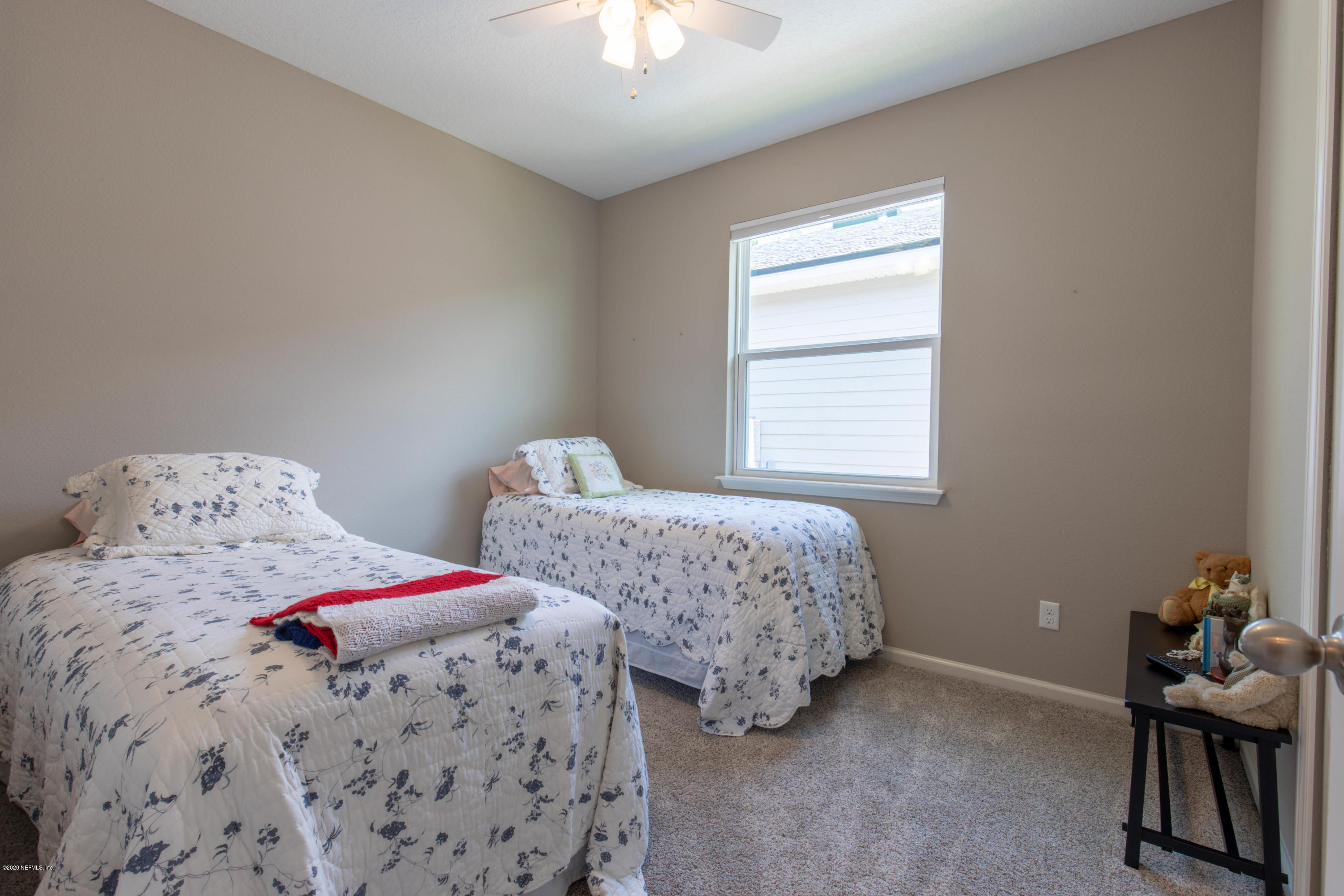 6642 Azalea Park Road Jacksonville, FL 32259 - Photo 17 of 42 a bedroom with two beds and a chandelier