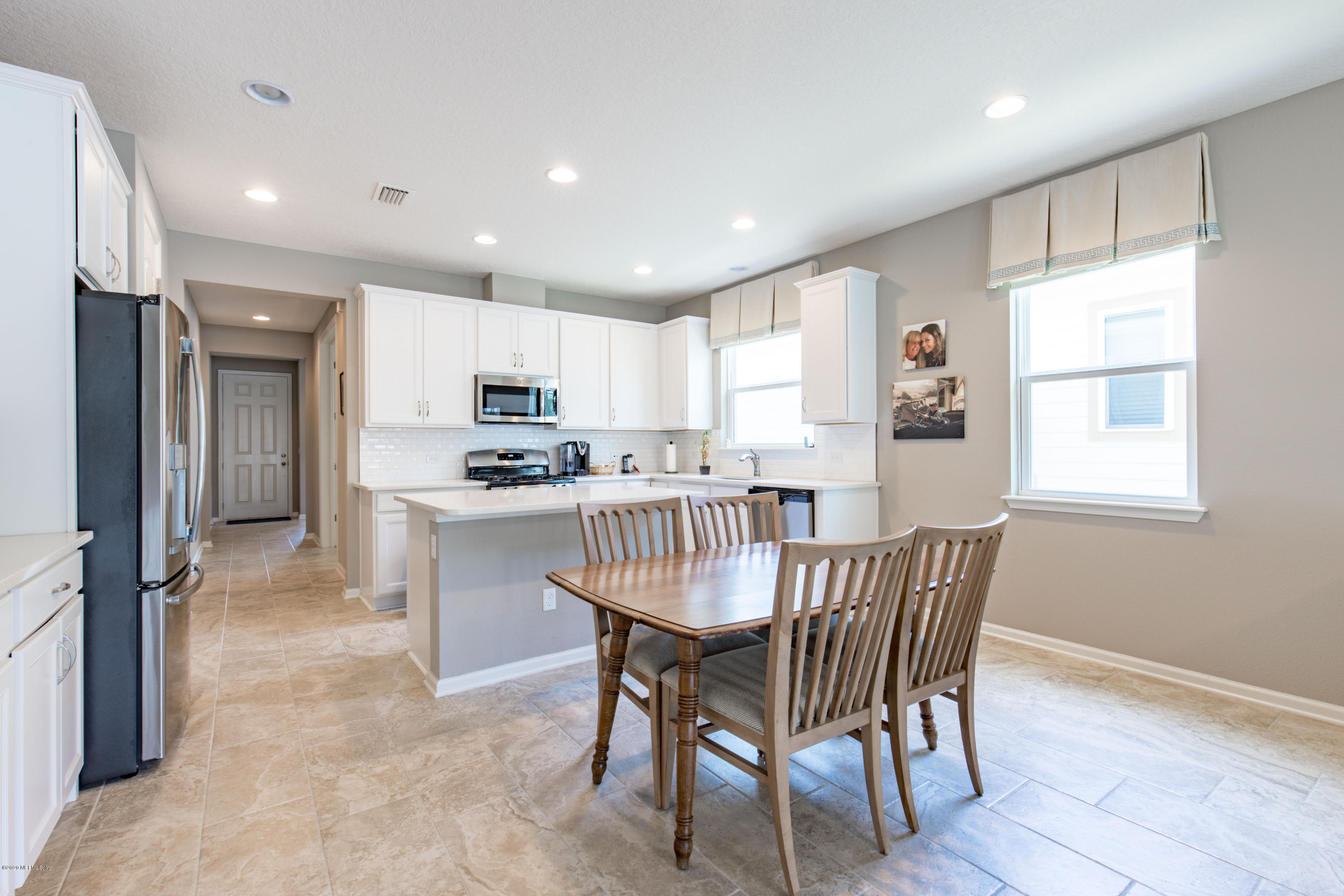 6642 Azalea Park Road Jacksonville, FL 32259 - Photo 8 of 42 a kitchen with kitchen island a dining table chairs refrigerator and cabinets