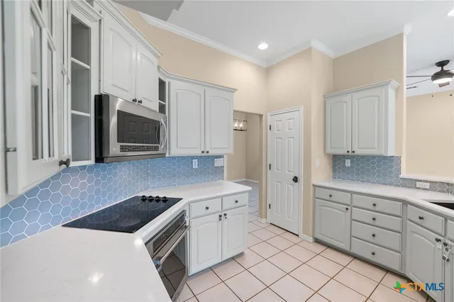 a kitchen with stainless steel appliances a sink cabinets and a window