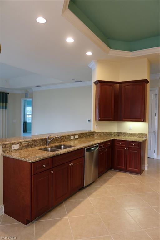 7168 Lemuria Circle, Unit 1701 Naples, FL 34109 - Photo 13 of 39 Kitchen featuring wood cabinetry, granite-finish countertops, and a double basin stainless steel sink with an integrated dishwasher