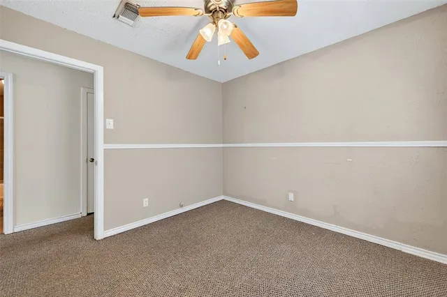 an empty room with a chandelier fan
