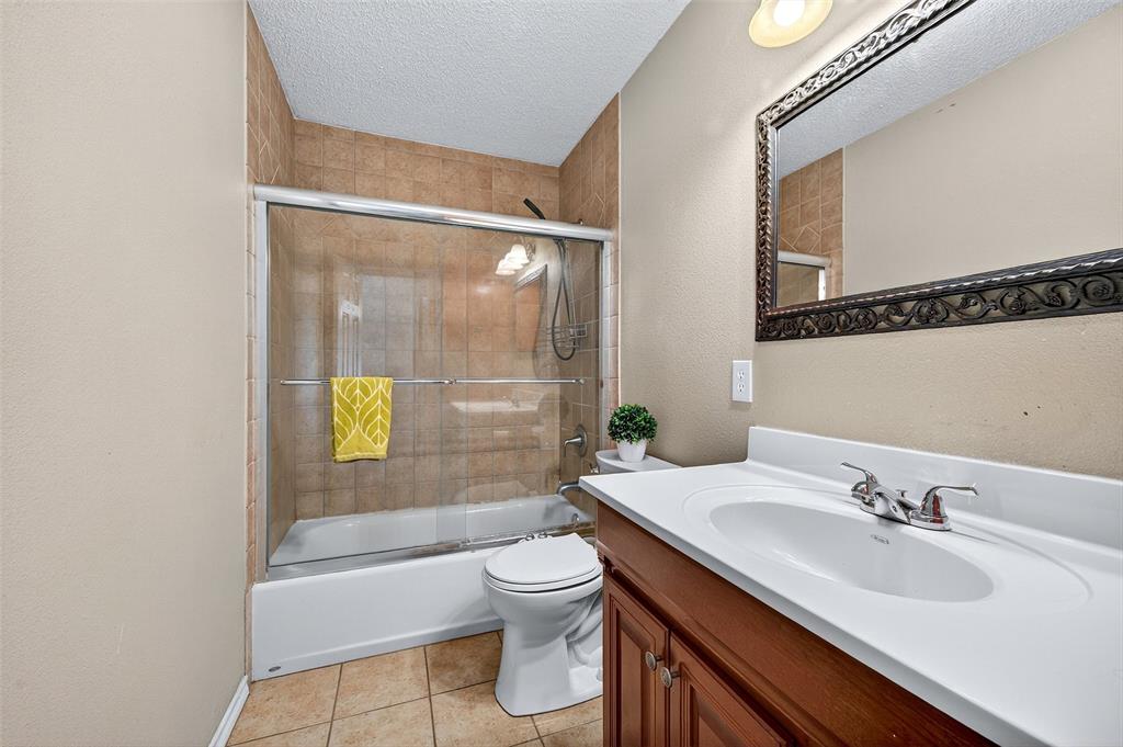 606 South Gordon Street Sherman, TX 75092 - Photo 12 of 22 a bathroom with a granite countertop sink toilet and shower