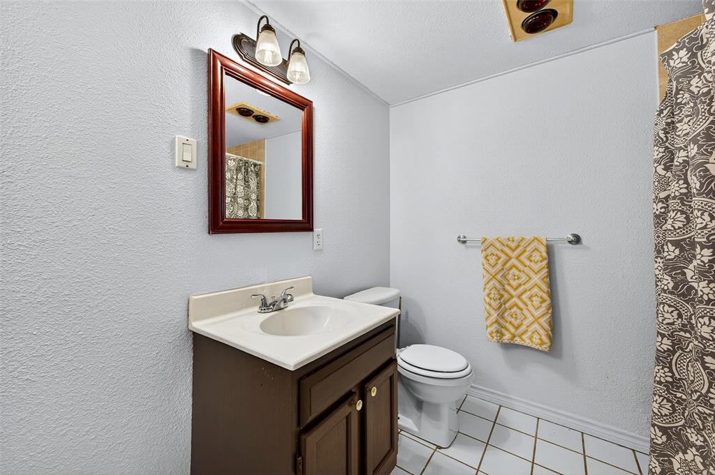 606 South Gordon Street Sherman, TX 75092 - Photo 19 of 22 a bathroom with a toilet sink and mirror