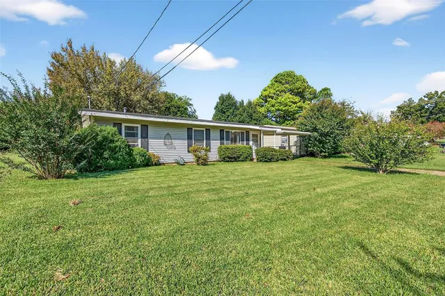 a view of a house with backyard and sitting area