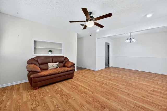a living room with a bed furniture and ceiling fan