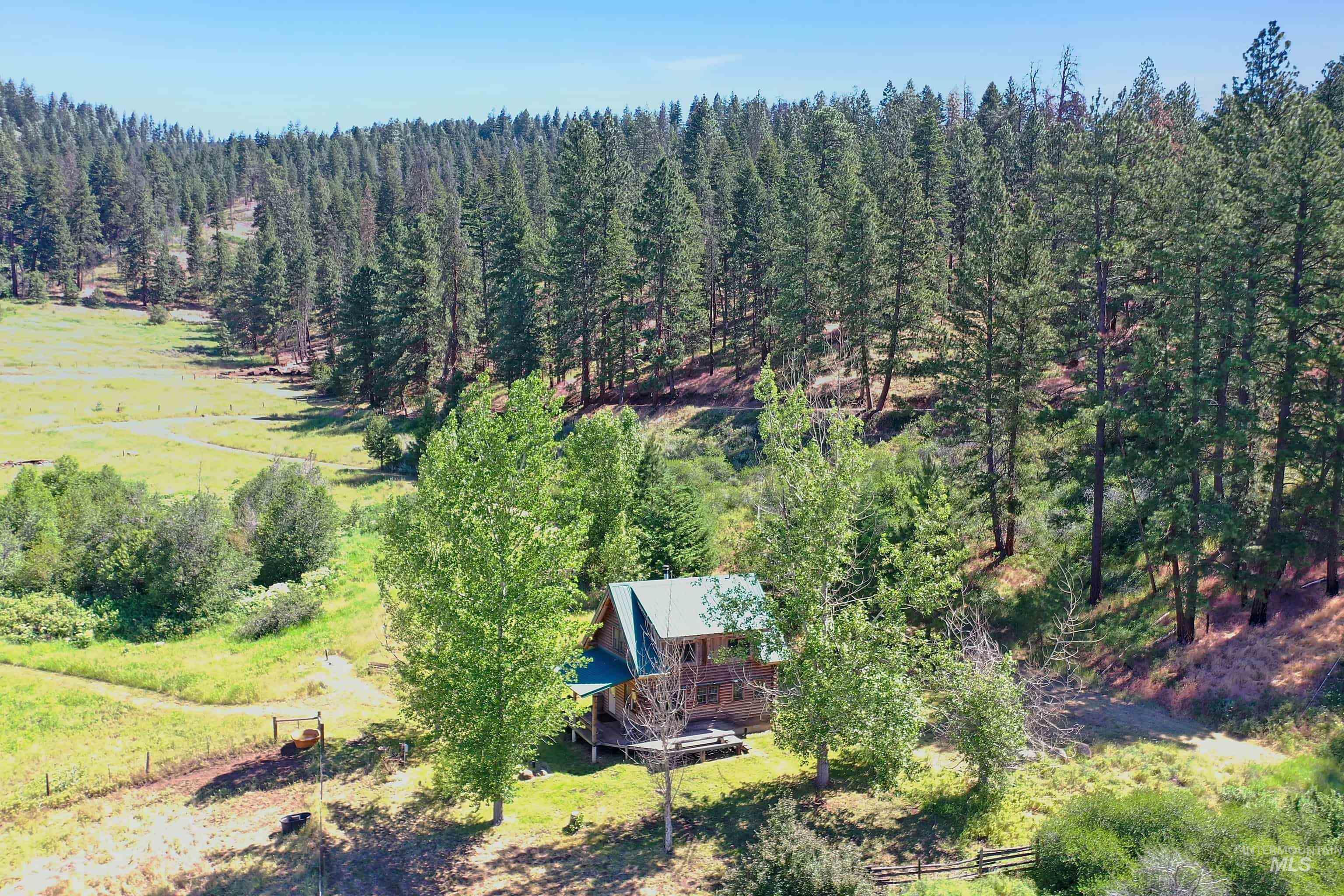 2150 Seid Creek Road Cambridge, ID 83610 - Photo 48 of 50 Rustic log-sided structure with a gabled roof and covered front porch, situated within a vast wooded landscape
