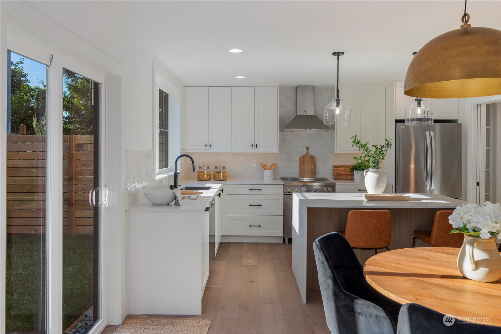 3014 East Howell Street Seattle, WA 98122 - Photo 7 of 39 a kitchen with stainless steel appliances a table chairs refrigerator and sink