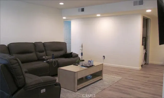 a living room with furniture and a wooden floor