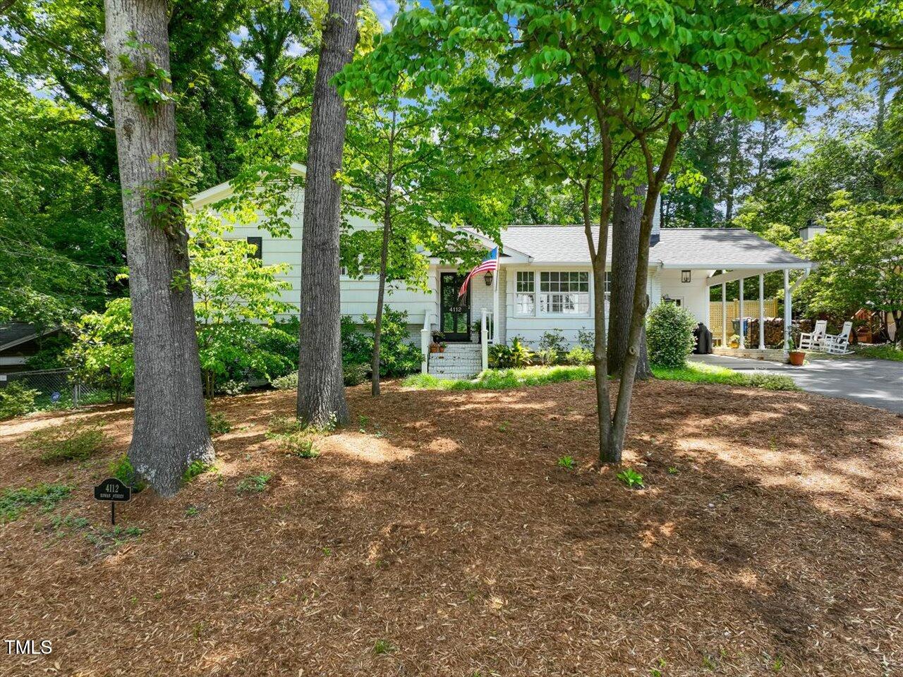 a view of a house with a tree in the forest
