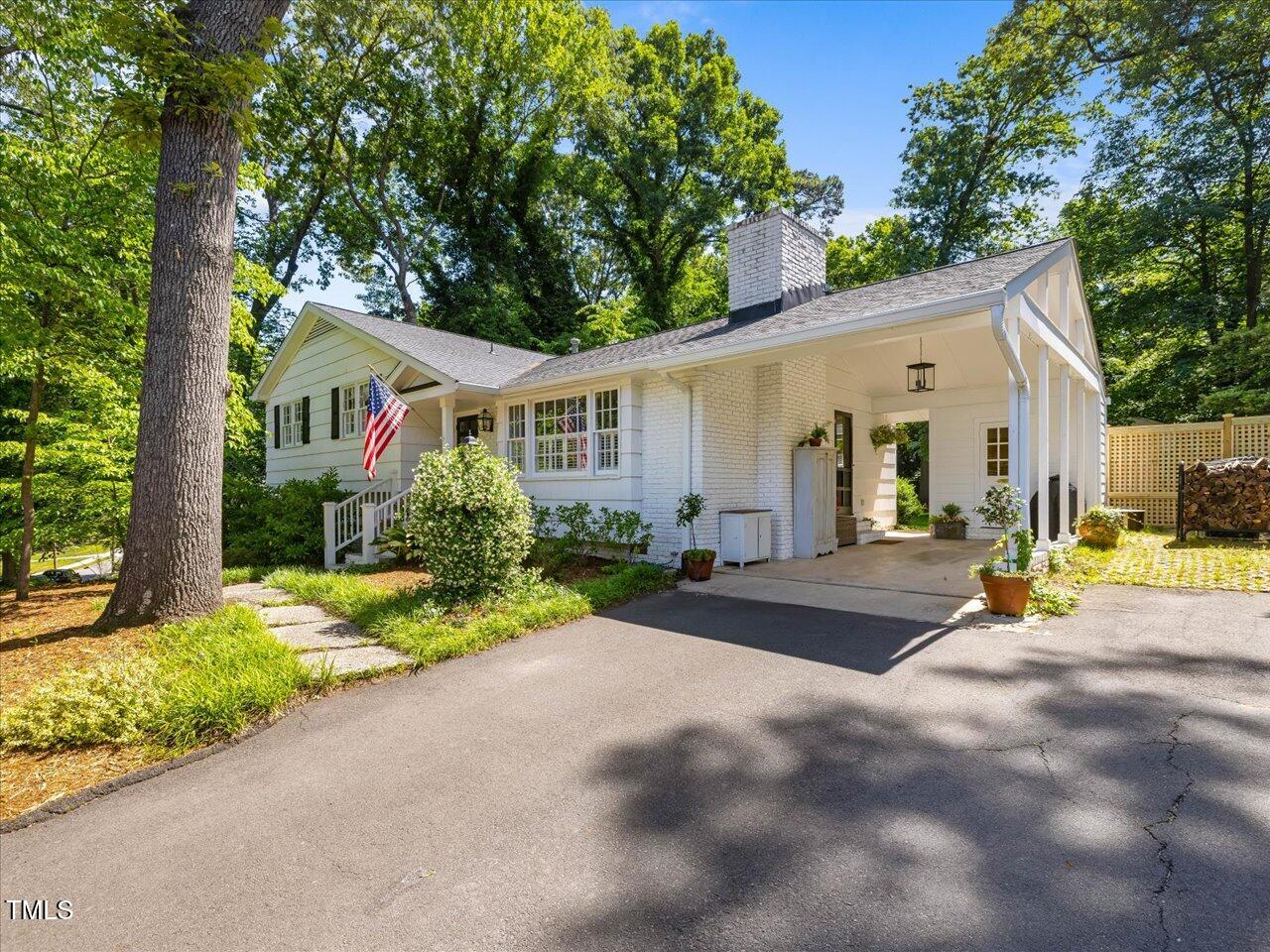4112 Rowan Street Raleigh, NC 27609 - Photo 2 of 35 a view of a white house with a big yard plants and large trees