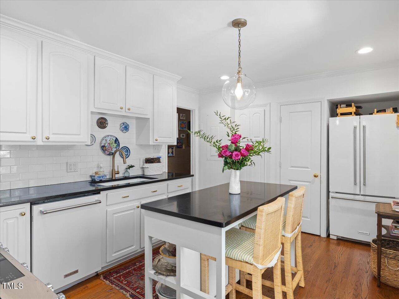 4112 Rowan Street Raleigh, NC 27609 - Photo 8 of 35 a kitchen with stainless steel appliances granite countertop a dining table chairs and white cabinets