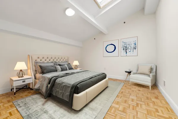 a spacious bedroom with a bed and a lamp