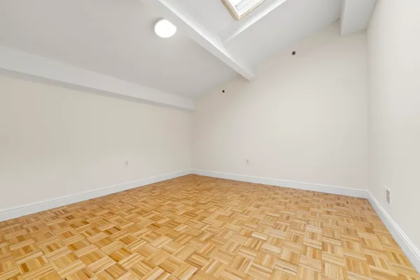 a bedroom with a bed and a flat tv screen on the dresser