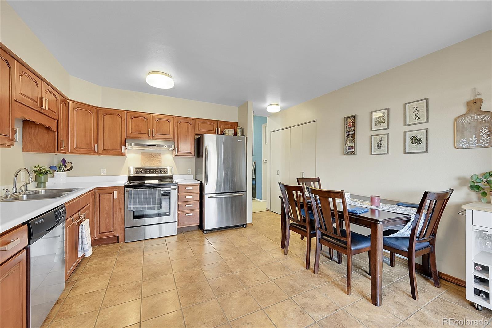 6495 East Happy Canyon Road, Unit 174 Denver, CO 80237 - Photo 11 of 32 a kitchen with stainless steel appliances a refrigerator stove microwave and a dining table