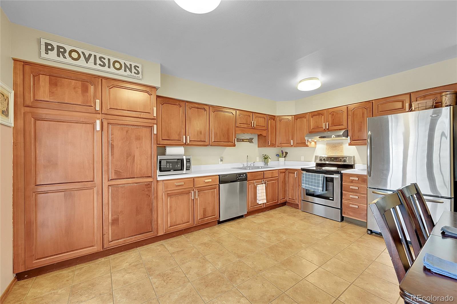 6495 East Happy Canyon Road, Unit 174 Denver, CO 80237 - Photo 12 of 32 a kitchen with stainless steel appliances a refrigerator sink and cabinets
