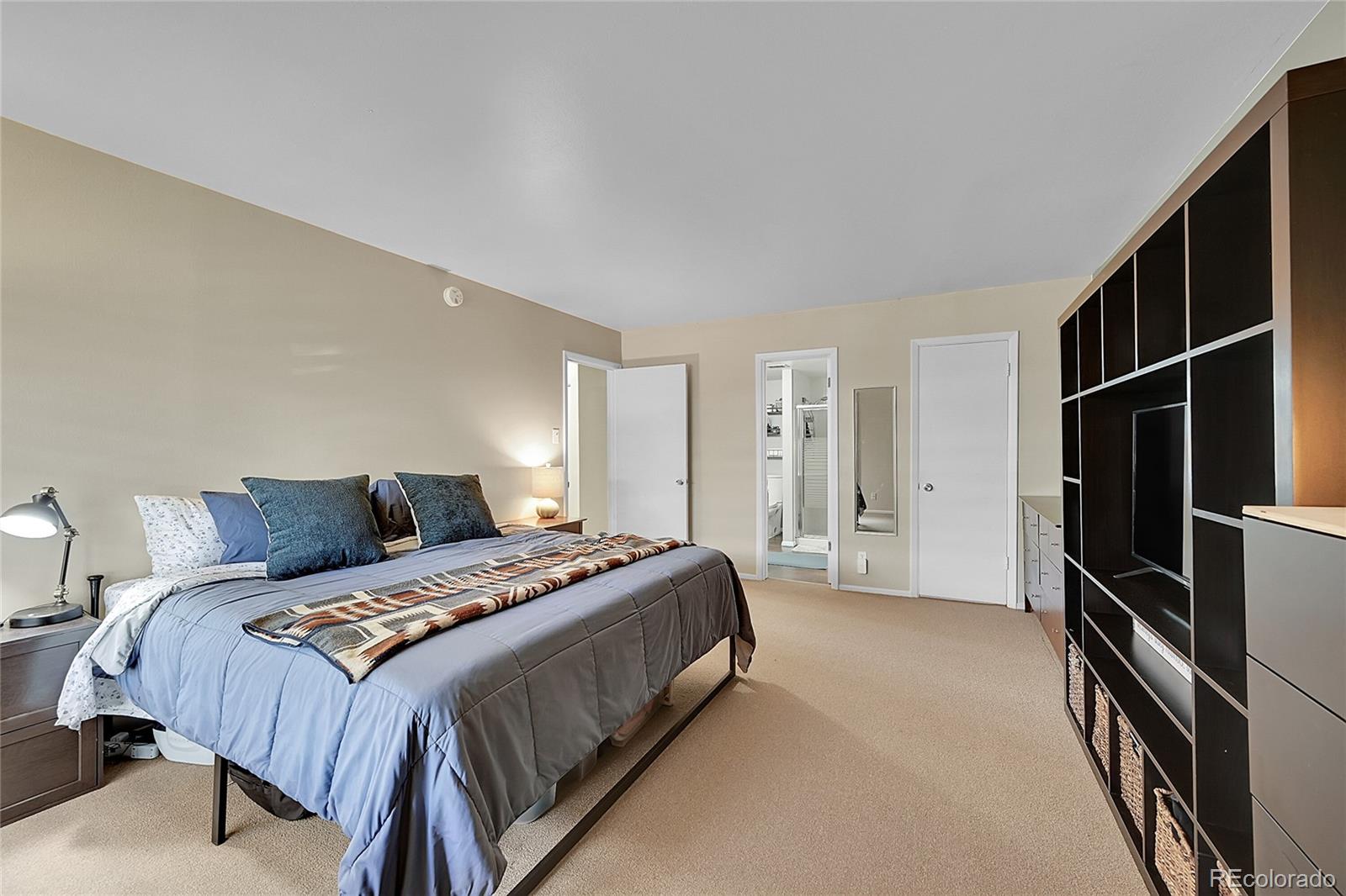 6495 East Happy Canyon Road, Unit 174 Denver, CO 80237 - Photo 15 of 32 a bedroom with a bed closet and a flat tv screen
