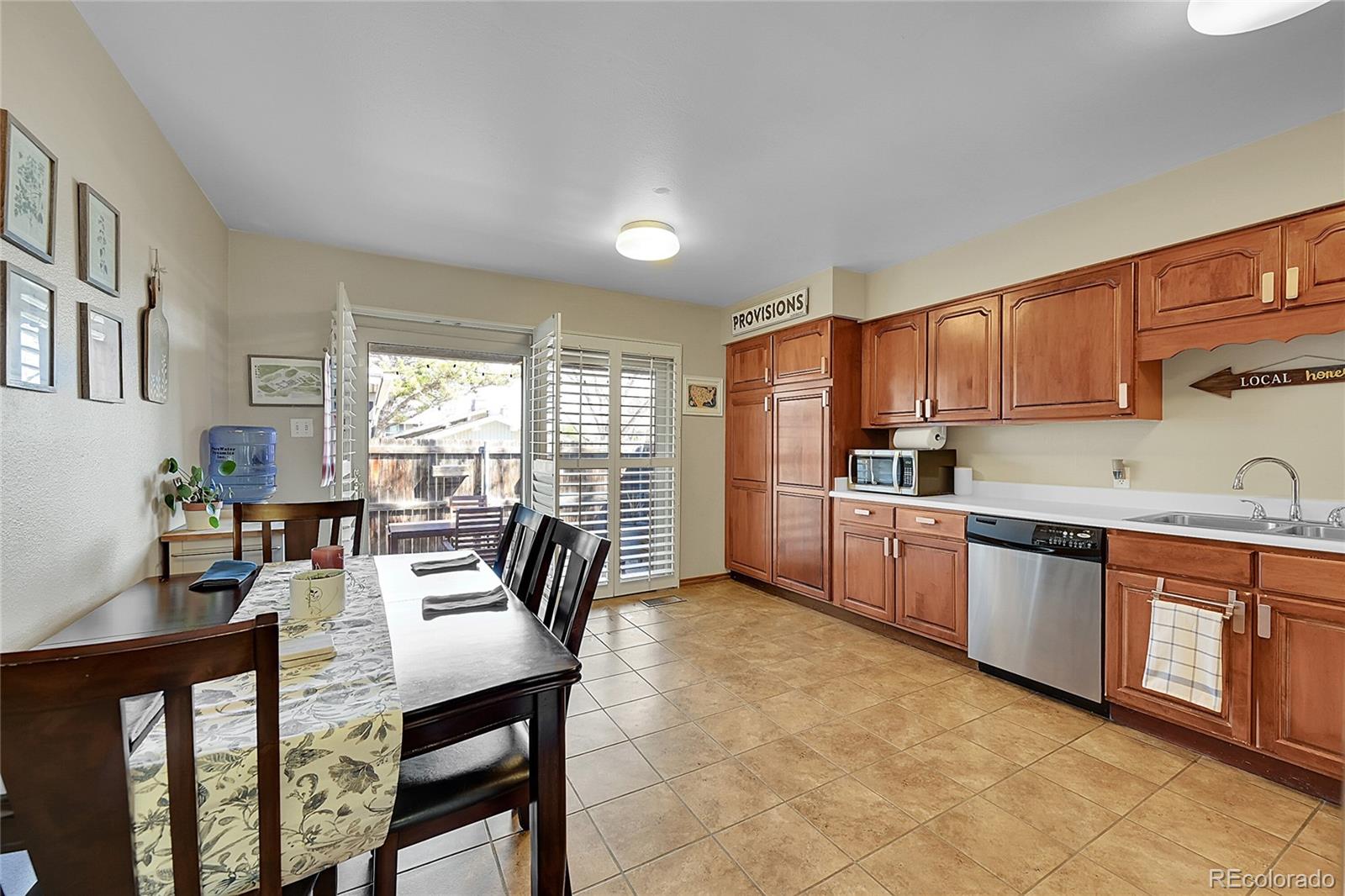 6495 East Happy Canyon Road, Unit 174 Denver, CO 80237 - Photo 9 of 32 a kitchen with stainless steel appliances granite countertop a stove a sink dishwasher a dining table and chairs with wooden floor