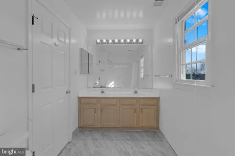 a large bathroom with a sink a mirror and a bathtub