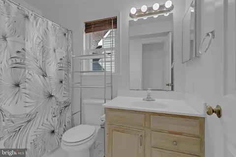a bathroom with a sink vanity mirror and toilet