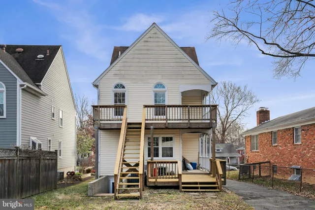 a view of a white house with large windows next to a road