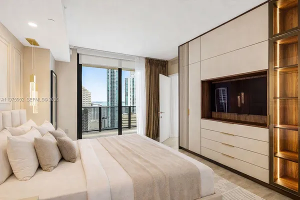 a bedroom with a bed and a large window