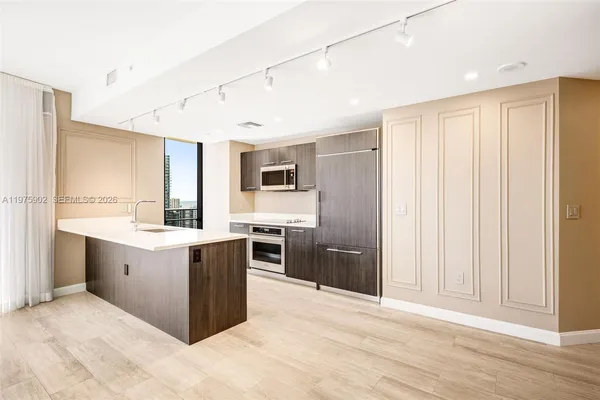 a kitchen with stainless steel appliances granite countertop a refrigerator and a sink