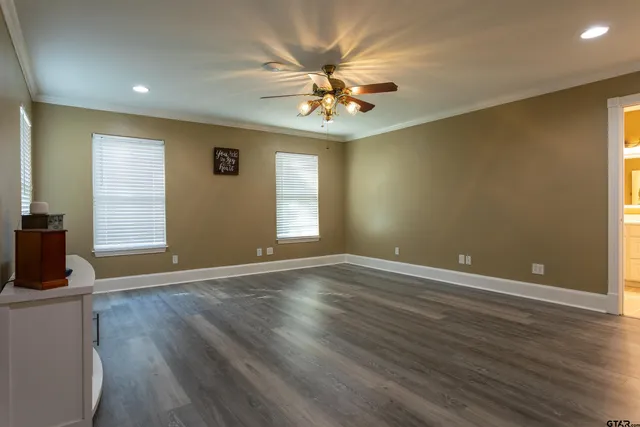 a view of an empty room with window and wooden floor