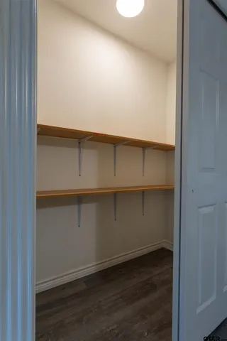 a living room with walk in closet and wooden floor
