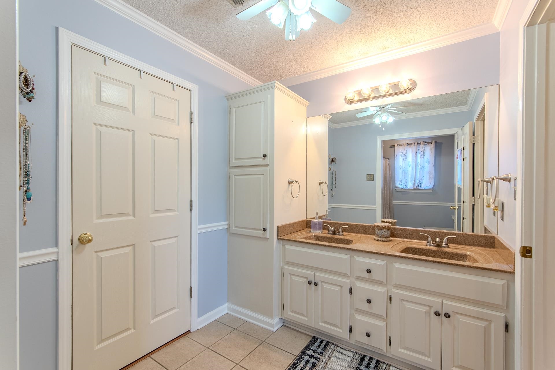 345 Dancer Road Selmer, TN 38375 - Photo 14 of 24 Bathroom featuring double vanity, light tile patterned flooring, a ceiling fan, a textured ceiling, and crown molding