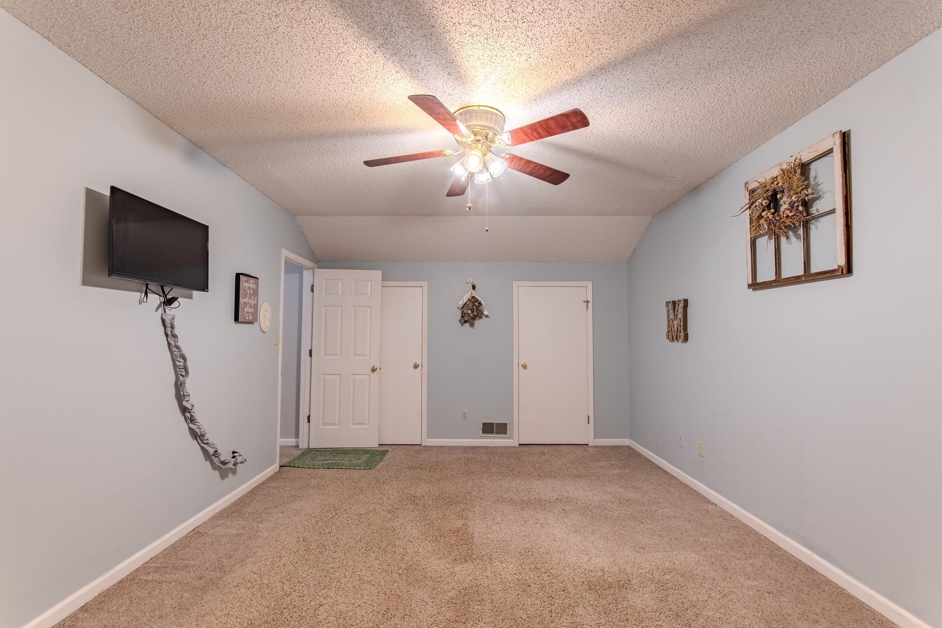 345 Dancer Road Selmer, TN 38375 - Photo 17 of 24 Unfurnished bedroom with vaulted ceiling, carpet floors, ceiling fan, and a textured ceiling