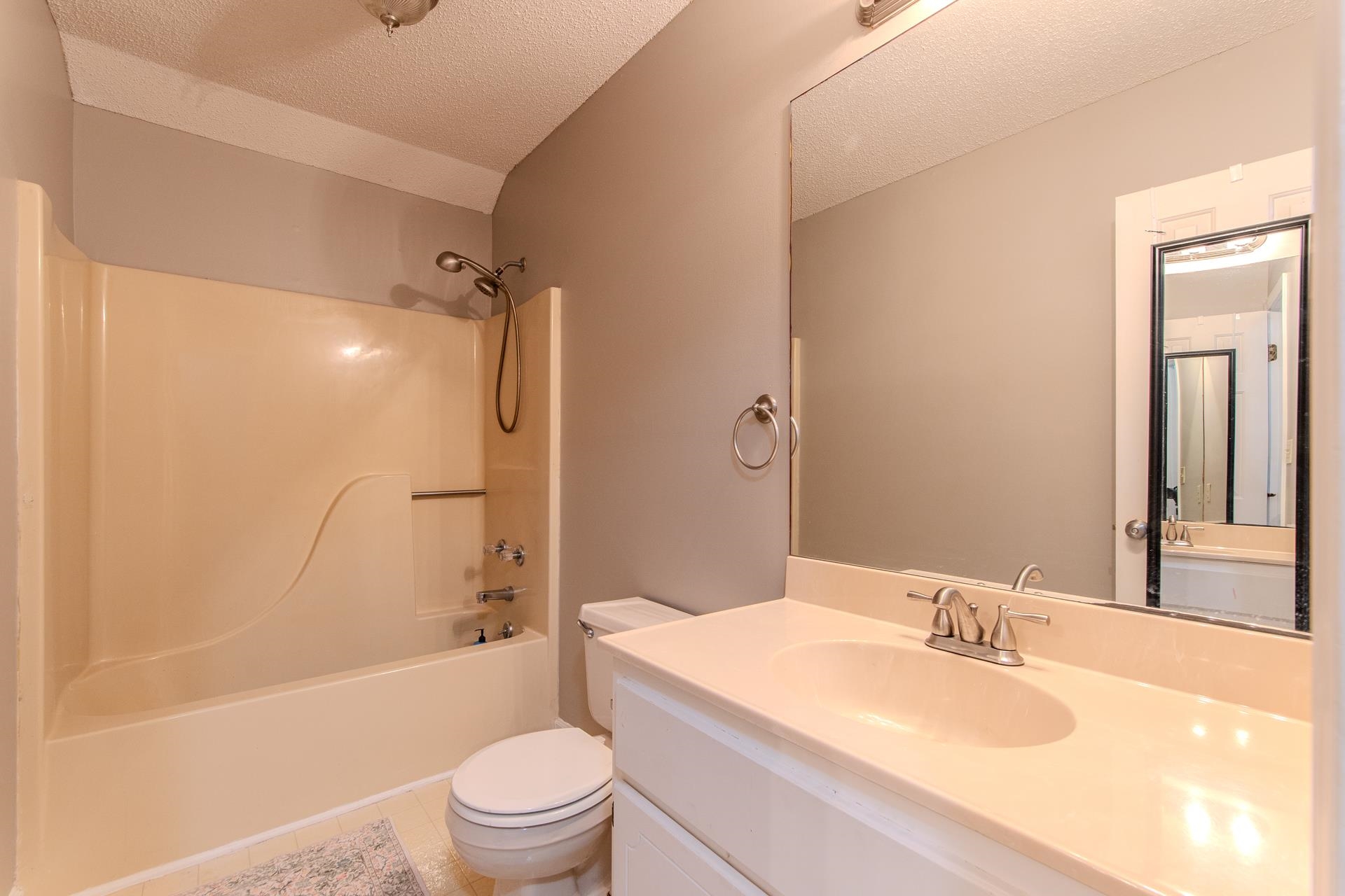 345 Dancer Road Selmer, TN 38375 - Photo 18 of 24 Bathroom featuring a textured ceiling, vanity, tub / shower combination, and light tile patterned floors