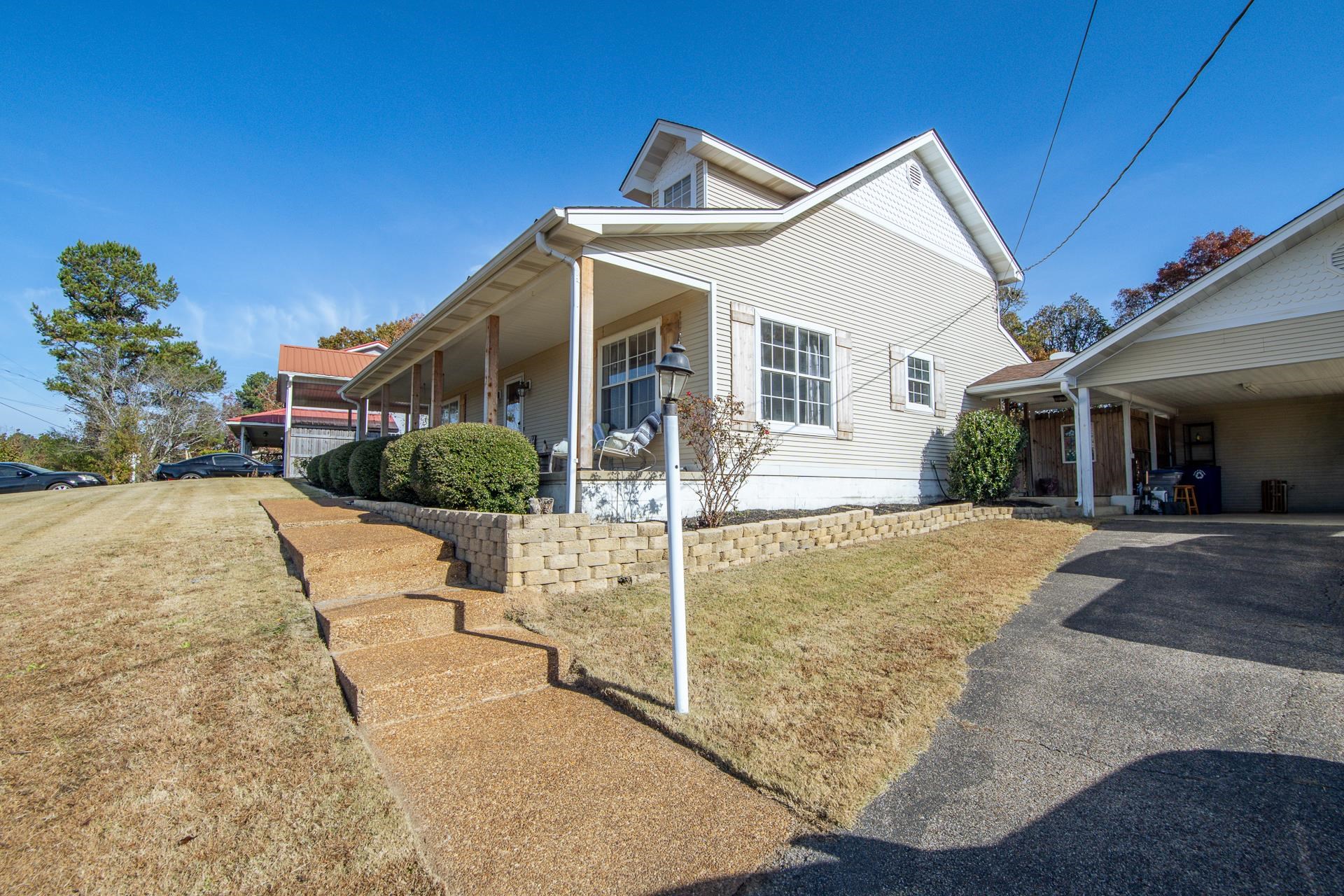 345 Dancer Road Selmer, TN 38375 - Photo 5 of 24 View of home's exterior featuring a lawn, covered porch, an attached carport, and asphalt driveway