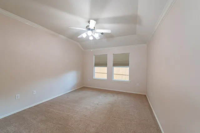 an empty room with a window and a fan