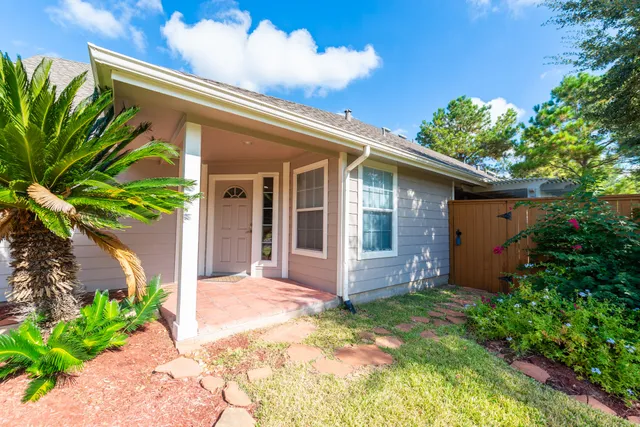 a backyard of a house with potted plants and brick wall