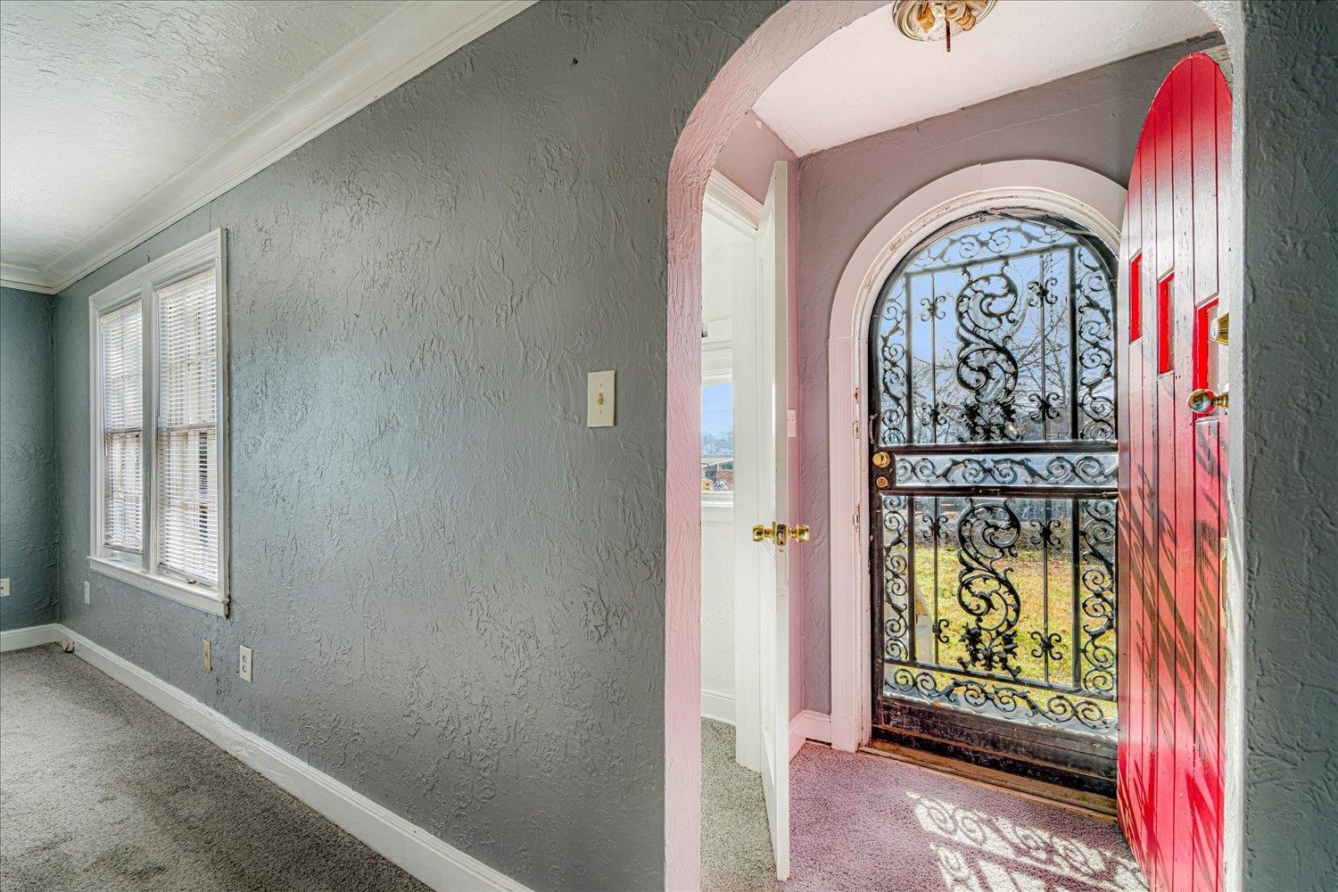 1114 Brownlee Road Memphis, TN 38116 - Photo 7 of 32 Entryway with a textured wall, carpet, a textured ceiling, arched walkways, and crown molding