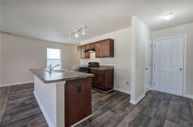 a kitchen with granite countertop a sink and a stove top oven