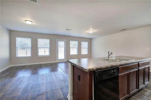 a kitchen with a granite countertop sink stove and cabinets