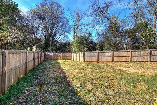 a view of a house with a yard and wooden fence