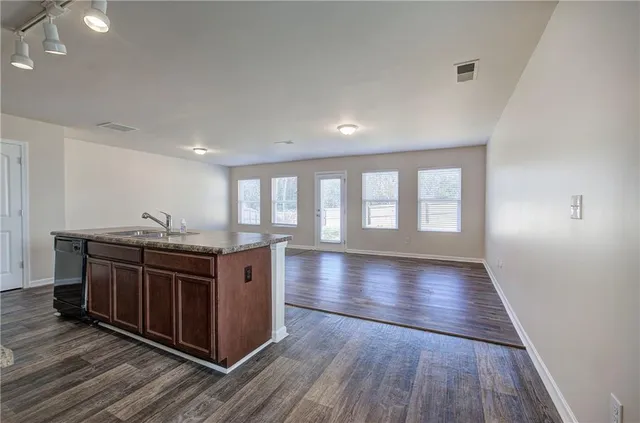 a kitchen with stainless steel appliances granite countertop a stove and a large window